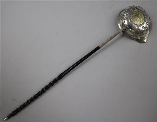 An 18ct century embossed silver toddy ladle with baleen handle and bowl with inset coin, 33cm.